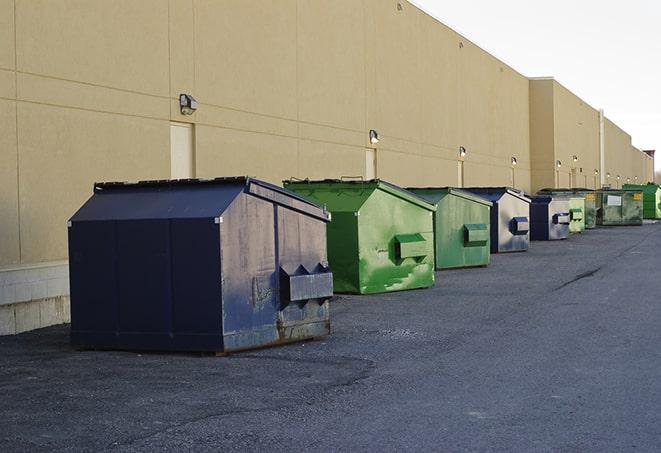 a row of blue construction dumpsters on a job site in Berea